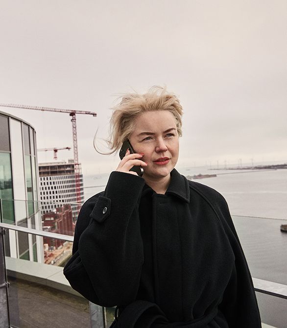 En ung kvinde med lyst hår taler i telefon